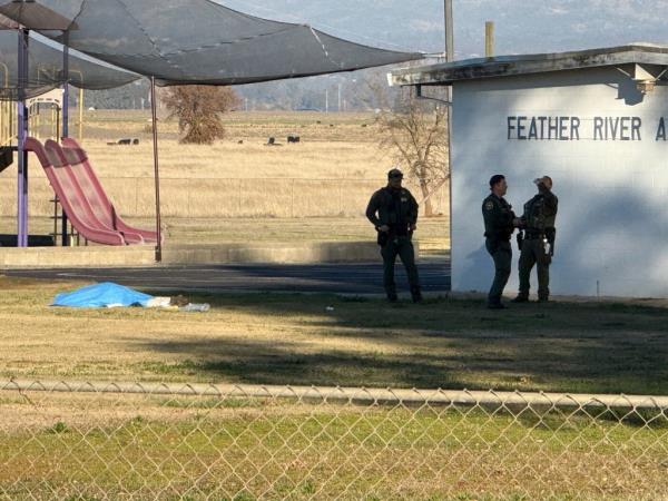 Police officers stand near a body covered by a tarp outside of Feather River Adventist School after a shooting Wednesday, Dec. 4, 2024, in Oroville, Calif.