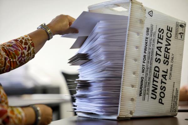 An election worker prepares absentee ballots for the upcoming general election before they are mailed to voters, at Wake County Board of Elections headquarters in Raleigh, North Carolina