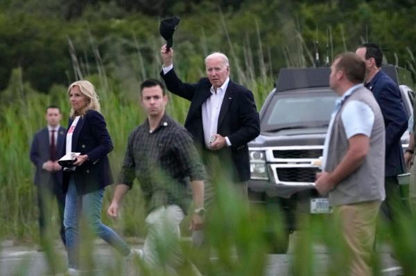 President Joe Biden, walking with first lady Jill Biden, gestures as he walks towards Marine One at Gordons Pond State Park near Rehoboth Beach, Del., Sunday, June 2, 2024. 