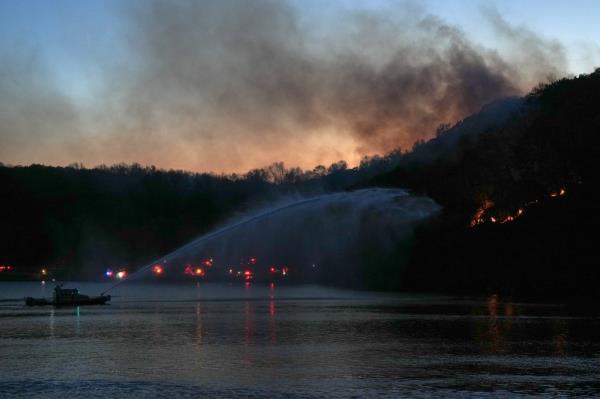 A New York City Fire Department (FDNY) boat works to put out a brush fire in the Inwood Hill Park section of northern Manhattan, New York, on November 13, 2024.