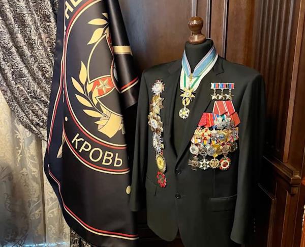 A suit decorated with various medals was found next to a flag that reads 