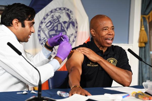 NYC Mayor Eric Adams receives his current Covid shot, administered by Dr. Ashwin Vasan, at City Hall.