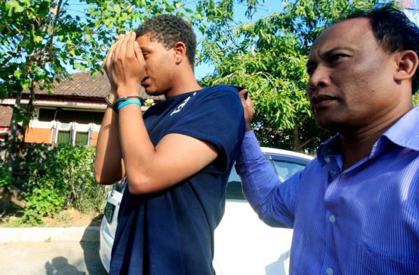An Indo<em></em>nesian police officer escorts Tommy Schaefer, left, as he is brought to the police station for questio<em></em>ning in relation to the death of his girlfriend's mother, in Bali, Indonesia, Wednesday, Aug. 13, 2014. 