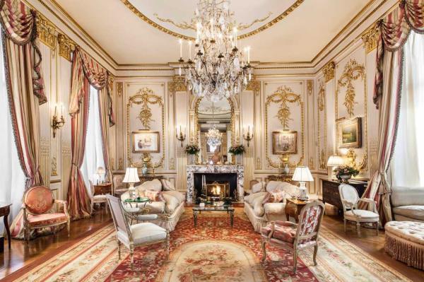 A formal living room with intricate paneling and high ceilings. 