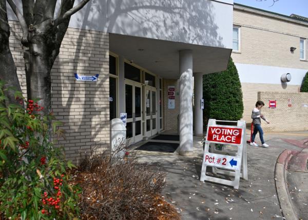 Voters heading to polling station with a voting sign on Super Tuesday in Charlotte, USA.