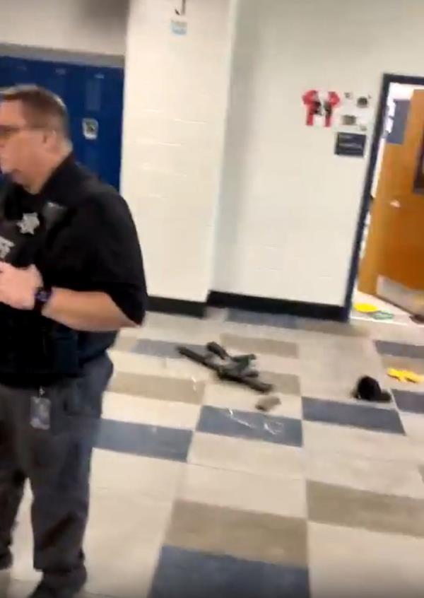 A law enforcement officer stands near the suspected gun used in Wednesday's shooting at Apalachee High School in Georgia. 