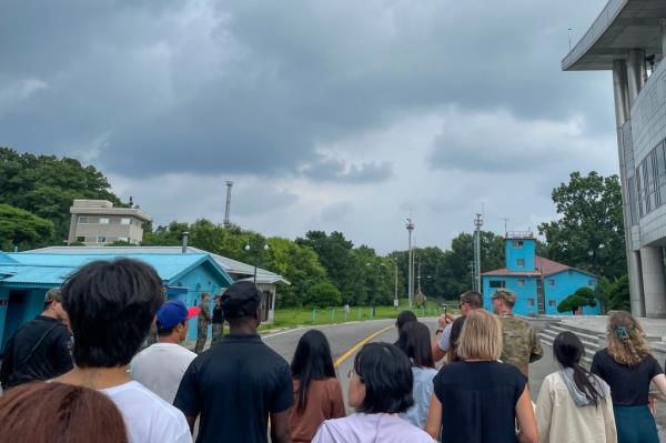 A group of tourists stand near a border station at Panmunjom.
