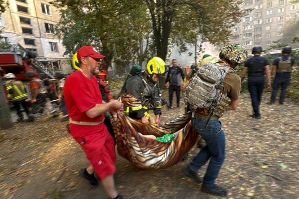Firefighters and paramedics carry out a strike victim from an apartment building.