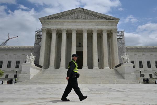 A police officer walks on the plaza of the US Supreme Court as the court hears arguments on the immunity of former US President Do<em></em>nald Trump, on April 25, 2024, in Washington, DC.