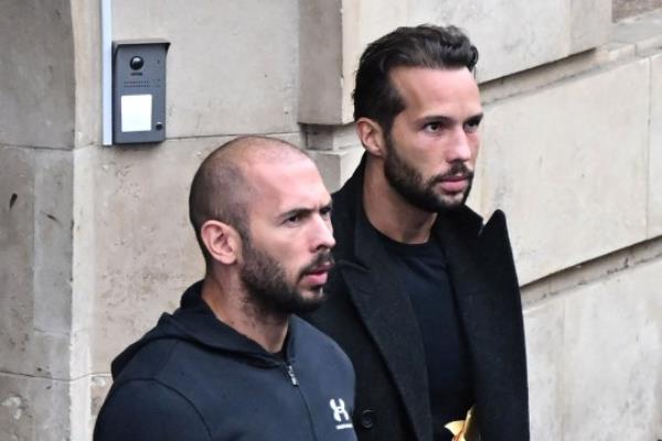 (FILES) In this file photo taken on January 10, 2023, British-US former professio<em></em>nal kickboxer and co<em></em>ntroversial influencer Andrew Tate (L) and his brother Tristan Tate (R) exit a court in Bucharest. - A Romanian court on March 31, 2023 ordered that co<em></em>ntroversial influencer Andrew Tate and his brother be moved from jail to house arrest while they are investigated for alleged human trafficking and rape. (Photo by Daniel MIHAILESCU / AFP) (Photo by DANIEL MIHAILESCU/AFP via Getty Images)