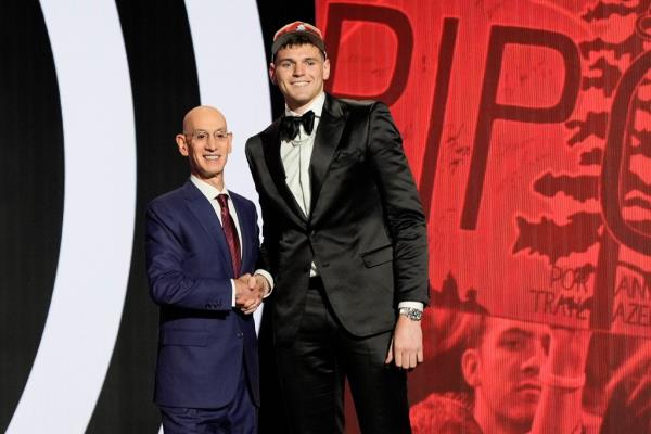 Do<em></em>novan Clingan (right) shakes NBA Commissio<em></em>ner Adam Silver's hand during the 2024 NBA Draft.