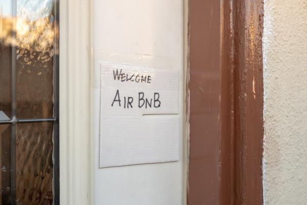 Close-up of hand drawn sign on door of a home reading Welcome AirBNB, indicating the home is made available for short term rental through the AirBNB website, Los Angeles, California, October 26, 2019.