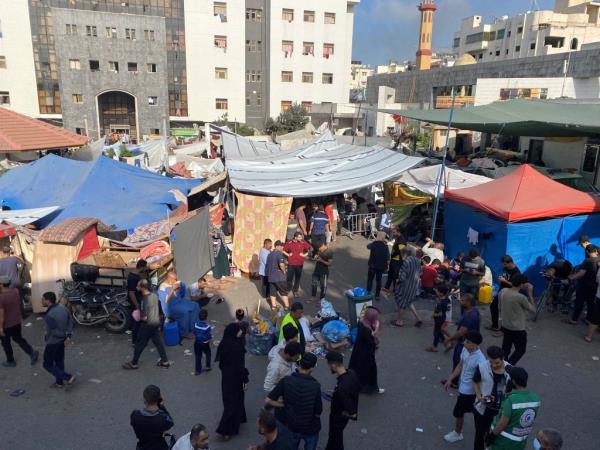 Displaced Palestinians gather at Al-Shifa hospital.