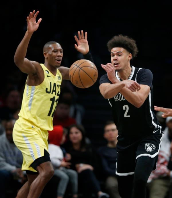 Brooklyn Nets forward Cam Johnson (2) passes the ball while defended by Utah Jazz guard Kris Dunn (11) during the second half of an NBA basketball game Sunday, April 2, 2023