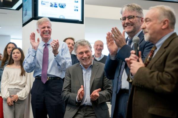 Washington Post Publisher Fred Ryan, foreground from left, Executive Editor Marty Baron, and Natio<em></em>nal Security Editor Peter Finn, applaud as investigative reporter Tom Hamburger speaks to the newsroom