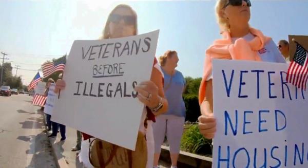 People gathered outside the Yarmouth Resort motel to protest plans for the latest migrant shelter in Massachusetts. 