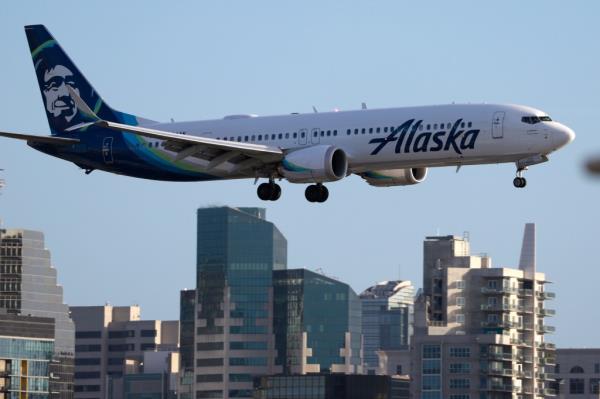 Alaska Airlines Boeing 737 MAX 9 aircraft approaching San Diego Internatio<em></em>nal Airport with residential and commercial buildings in the background