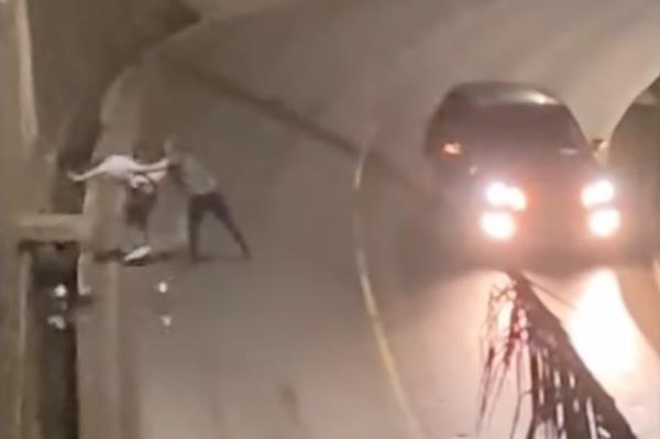 Screen shot from a video showing Rafael de Vasco<em></em>ncelos pushing his partner Eugene Staal off a highway into a ditch along the side of the road. 