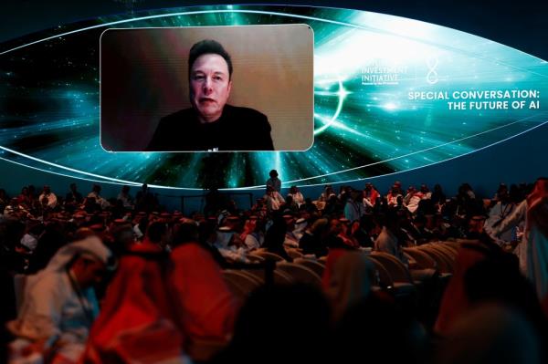 Elon Musk on a screen, virtually attending Future Investment Initiative in Saudi Arabia.