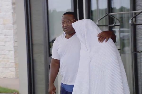 Rudy Farias, right, covered in a blanket as he exits a treatment facility Wednesday with activist Quanell X.