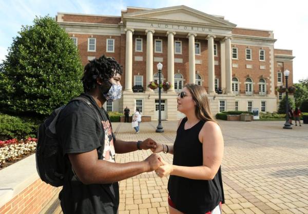 Two people holding hands on the University of Alabama campus.