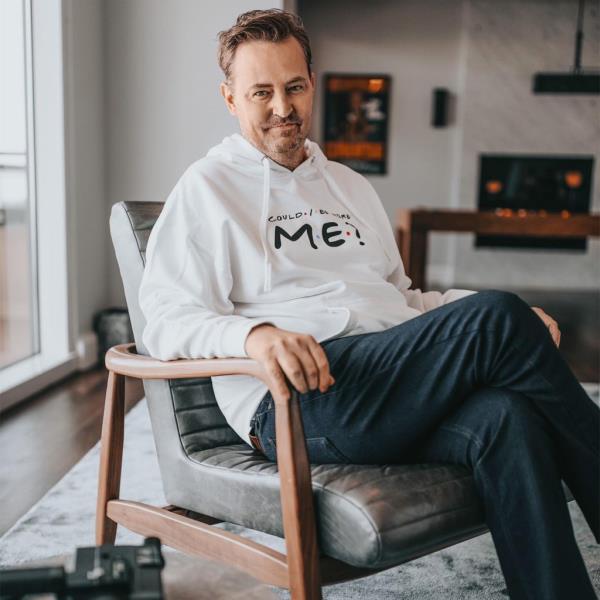 Matthew Perry poses for a photo  while sitting on a chair indoors
