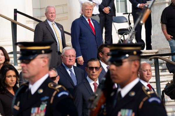 Bob Quackenbush, top left, deputy chief of staff for Arlington Natio<em></em>nal Cemetery, and Republican presidential nominee former President Do<em></em>nald Trump watch the changing of the guard at the Tomb of the Unknown Solider