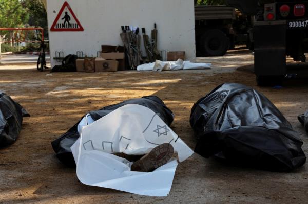 The covered body of a man lies on the ground following an attack by Gazan militants.