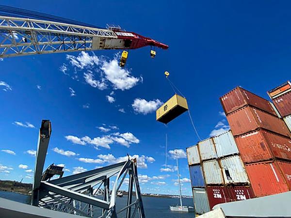 Respo<em></em>nse crews begin removing shipping co<em></em>ntainers from the deck of the cargo ship Dali using a floating crane barge at the site of the Francis Scott Key Bridge on April 7, 2024, in Baltimore. 
