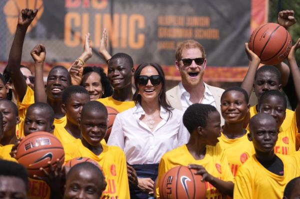 Prince Harry and Meghan, Duchess of Sussex, posing with children at Dream Big Basketball clinic in Lagos Nigeria, as part of the Invictus Games event