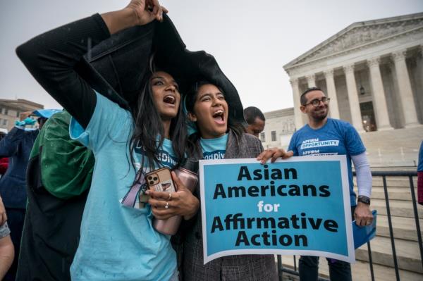 Girls hold a sign outside of the Supreme Court reading 