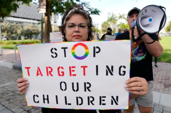 A person who gave her name as Marlene holds a sign as she protests outside of a Target store.