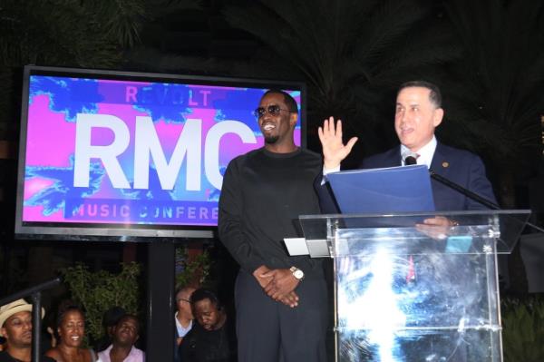 Sean 'Diddy' Combs standing at a podium with Mayor Philip Levine at the 2016 REVOLT Music Co<em></em>nference in Miami Beach, Florida