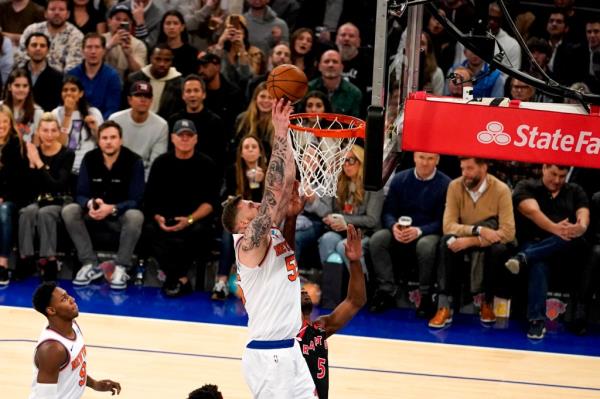 Knicks center Isaiah Hartenstein, center top, attempts a dunk