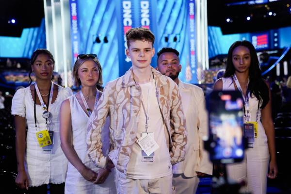 Influencer Merrick Hannah recording a video at the Democratic Natio<em></em>nal Co<em></em>nvention in Chicago, surrounded by a group of people, including celebrity Guy Sebastian