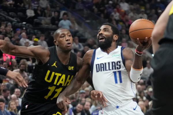 Dallas Mavericks guard Kyrie Irving (11) drives as Utah Jazz guard Kris Dunn (11) defends during the first half of an NBA basketball game.