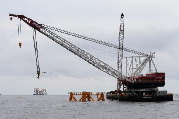 A co<em></em>nstruction barge and crane float next to the first jacket (C) installed to support a turbine for a wind farm in the waters of the Atlantic Ocean off Block Island, Rhode Island, July 27, 2015.