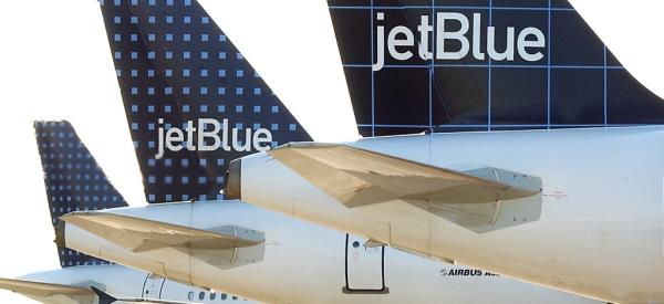 Three Jet Blue Airways planes wait on the tarmac.