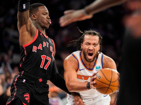 Jalen Brunson fights through co<em></em>ntact from Toro<em></em>nto Raptors guard Dennis Schroder.