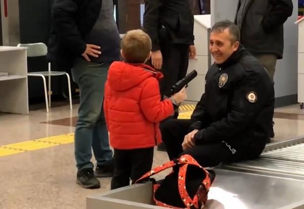 Selim K?se, 6, shows a toy gun to a police officer at the DHM Yenisehir Airport in Bursa, Turkey