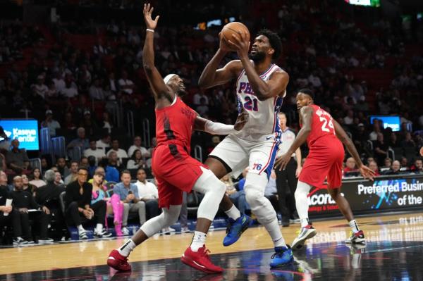 Philadelphia 76ers center Joel Embiid (21) goes to the basket as Miami Heat center Bam Adebayo, left, defends during the first half of an NBA basketball game, Monday, Nov. 18, 2024, in Miami.  