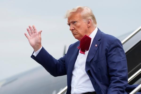 Former President Do<em></em>nald Trump waves as he steps off his plane at Ro<em></em>nald Reagan Washington Natio<em></em>nal Airport, Aug. 3, 2023.