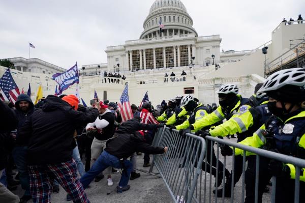 In this Wednesday, Jan. 6, 2021 file photo, Trump supporters try to break through a police barrier at the Capitol in Washington.
