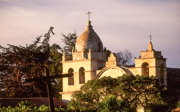The dome shaped bell and square bell towers crown the facade of historic Old Mission San Carlos Borromeo, second of nine missions established by Fr. Junipero Serra in 1770, and site of his tomb, is located in Carmel Valley on the Mo<em></em>nterey Peninsula in Northern California.