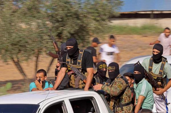 Palestinian militants move towards the border fence with Israel from Khan Yunis in the southern Gaza Strip on October 7, 2023. 