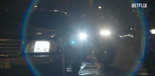 A car and motorcycles at night. 