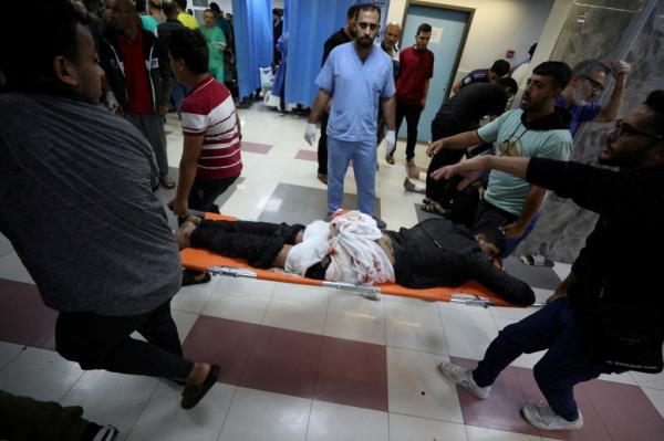 An injured person is assisted at Shifa Hospital after hundreds of Palestinians were killed in a blast at Al-Ahli hospital in Gaza that Israeli and Palestinian officials blamed on each other, in Gaza City, Gaza Strip, on Oct. 17, 2023. 