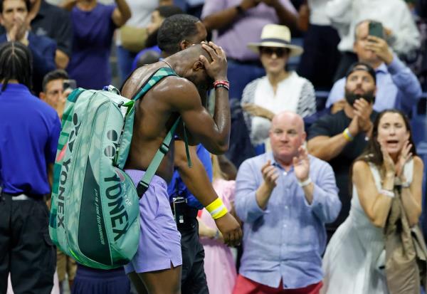 Frances Tiafoe of the United States puts his head in his hands as he leaves Arthur Ashe Stadium after losing his match against Taylor Fritz of the United States on day twelve of the U.S. Open