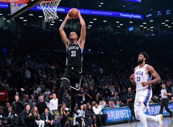 Nic Claxton slams the ball in front of Joel Embiid during the first quarter of game 3 in round 1 of the NBA Playoffs..
