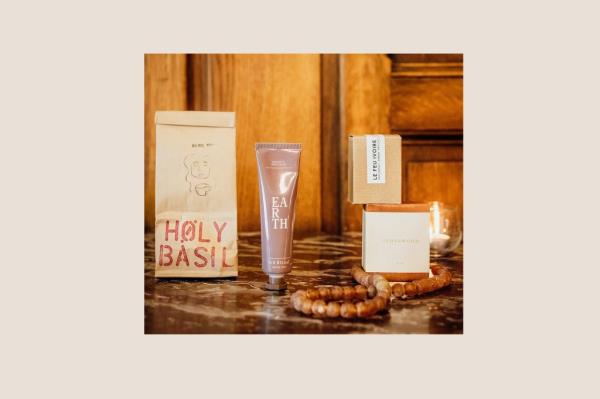 A group of wellness product bottles and a paper bag arranged on a marble surface, a part of Jessica Biel's favorite wellness box